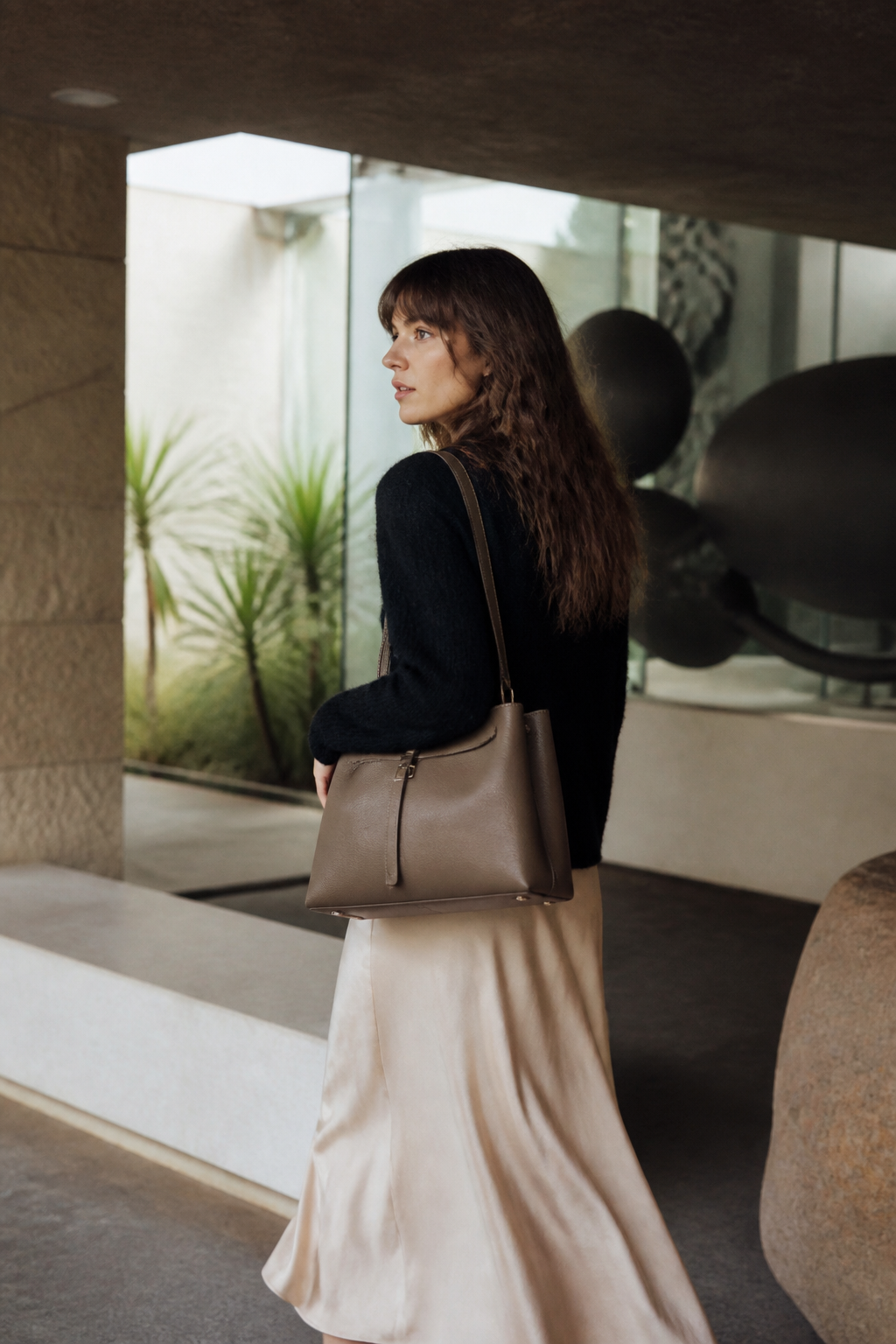Woman carrying a taupe Pakito shoulder bag