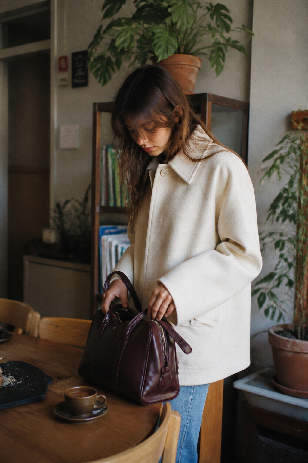 Woman holding a burgundy Pakito handbag indoors