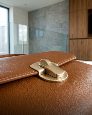 Metallic closure on a brown leather bag
