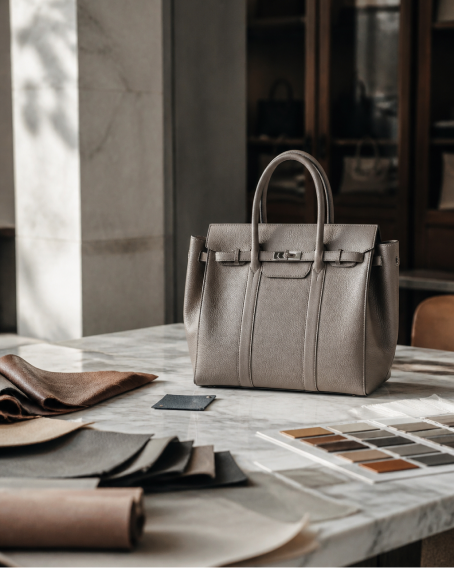 Gray Pakito handbag on a materials and leather worktable