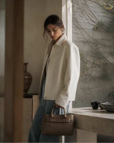 Woman carrying a brown Pakito handbag in a modern interior
